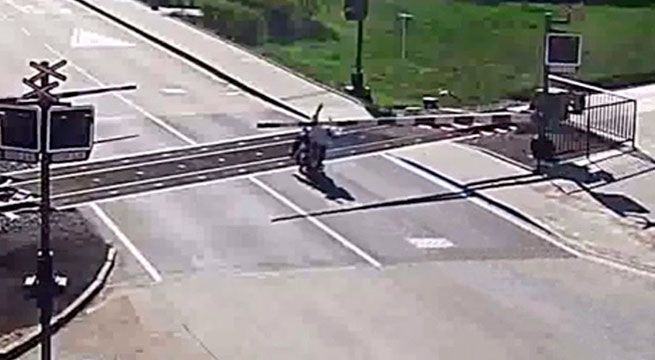 Motociclista cae sobre las vías del tren y ocurre algo inesperado [VIDEO]
