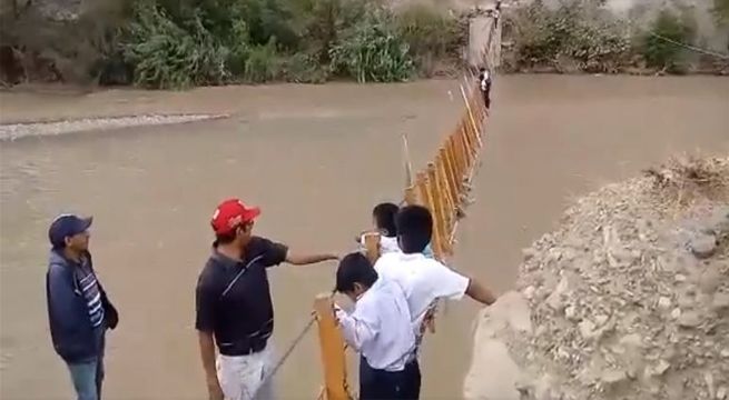 Niños cruzan puente dañado por lluvias para ir al colegio